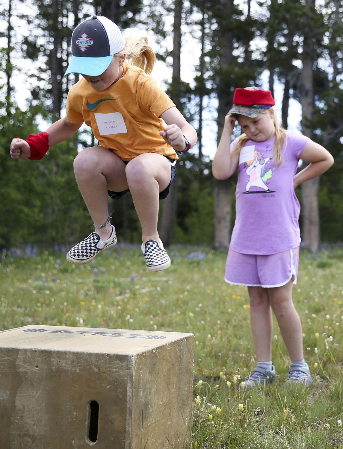 Paislee Stevens tucks her knees up while jumping with both feet onto the box